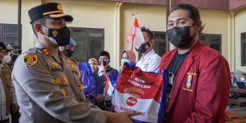 Angkat dan Kibarkan Bendera Merah Putih, Polres Probolinggo Gelar Vaksin Serentak dan Pendistribusian Bansos