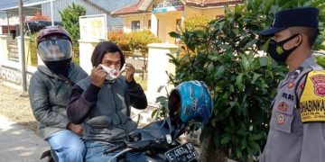 Tekan Penyebaran Covid-19, Polisi Terus Berikan Himbauan Prokes serta berikan masker dimasa PPKM